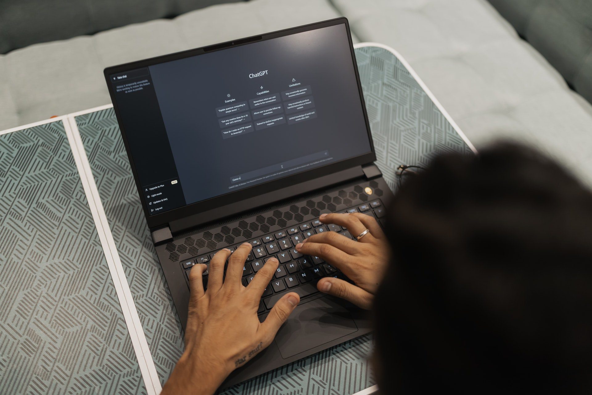 Man typing on a laptop looking at ChatGPT