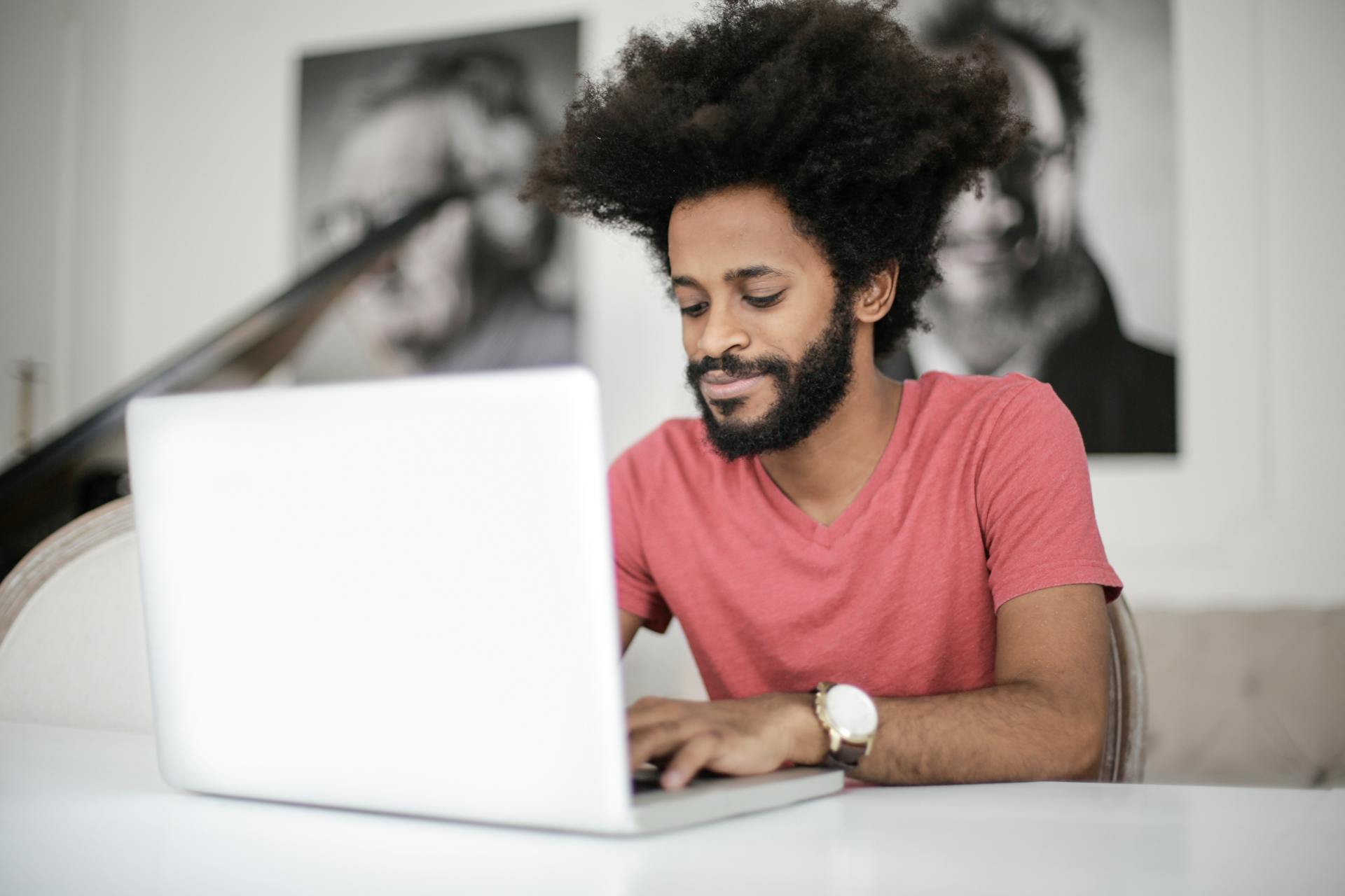 Man with large afro sitting at a computer typing a blog.